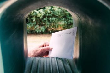 hand placing letter in a mailbox, direct mail campaign 